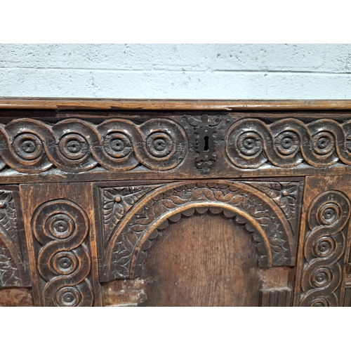 154 - AN LARGE ANTIQUE TRUNK, with nicely carved triple panel design to front, metal fittings, opening to ... 