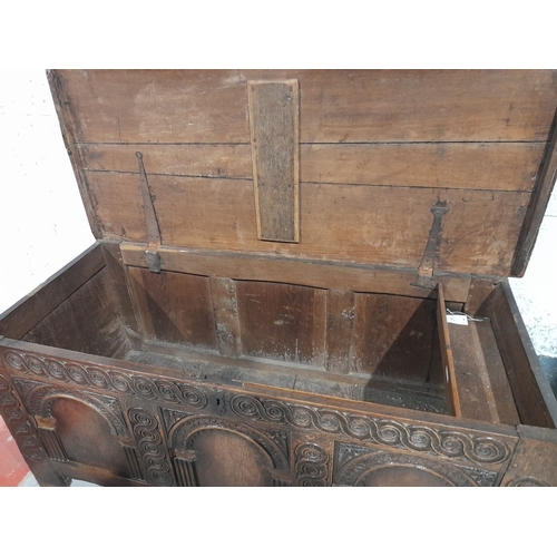 154 - AN LARGE ANTIQUE TRUNK, with nicely carved triple panel design to front, metal fittings, opening to ... 