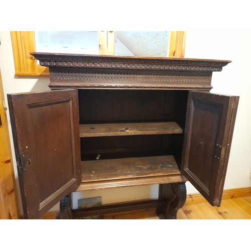 155 - A MAHOGANY TWO DOOR CABINET, with carved cornice above two panelled doors, opening to shelving, rais... 