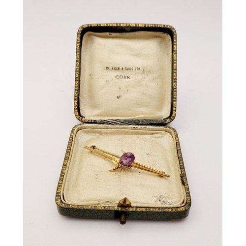 18 - A CASED 9CT YELLOW GOLD AND AMETHYST BROOCH, with a large oval cut amethyst stone in a claw setting ... 