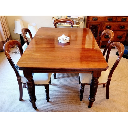 215 - A GOOD QUALITY 20TH CENTURY MAHOGANY DINING TABLE, with canted corners and raised on beautiful turne... 