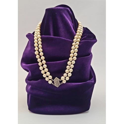 22 - A CLASSIC CULTURAL PEARL & GOLD CLASPED NECKLACE, the double hand knotted string of pearls is claspe... 