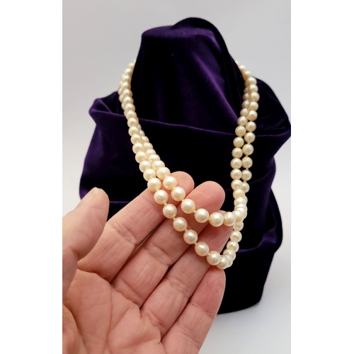 22 - A CLASSIC CULTURAL PEARL & GOLD CLASPED NECKLACE, the double hand knotted string of pearls is claspe... 