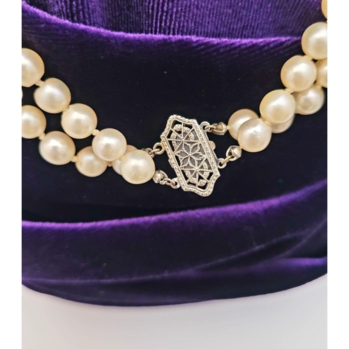 22 - A CLASSIC CULTURAL PEARL & GOLD CLASPED NECKLACE, the double hand knotted string of pearls is claspe... 