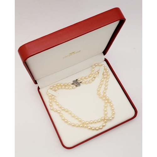 22 - A CLASSIC CULTURAL PEARL & GOLD CLASPED NECKLACE, the double hand knotted string of pearls is claspe... 