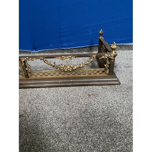 239 - A GOOD QUALITY STEEL & BRASS FENDER, with four finials to top rail, central panel with torch surroun... 