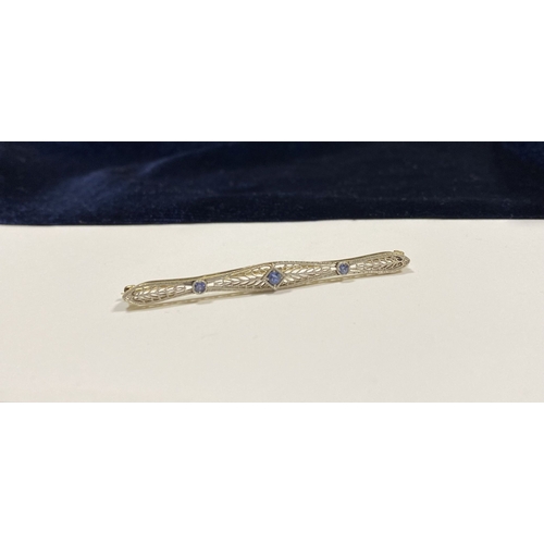 24 - A BEAUTIFUL ART DECO 14CT GOLD SAPPHIRE BAR BROOCH, set with three vibrant round cut sapphires, the ... 