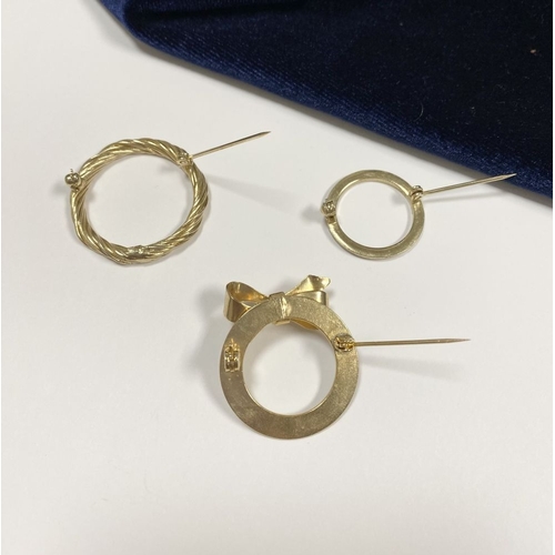 244 - A TRIO OF GILT CIRCULAR BROOCHES, one with rope design, one mounted with bow and simulated pearl to ... 