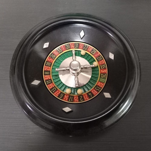 272 - A VINTAGE BAKELITE ROULETTE WHEEL, and felt playing mat, the wheel: 16cm diameter. Complete with car... 