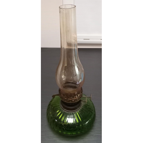 278 - A VICTORIAN GREEN GLASS OIL LAMP, with clear glass chimney. 37cm high overall 16cm diameter