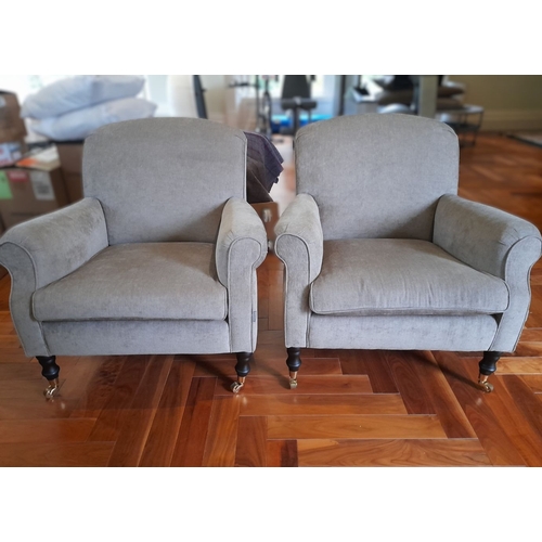 286 - A PAIR OF GREY UPHOLSTERED ARMCHAIRS, on turned leg with castors. Dimensions: 84cm wide x 82cm high ... 