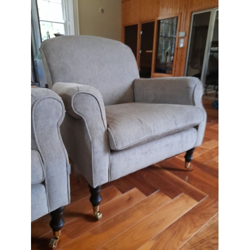 286 - A PAIR OF GREY UPHOLSTERED ARMCHAIRS, on turned leg with castors. Dimensions: 84cm wide x 82cm high ... 