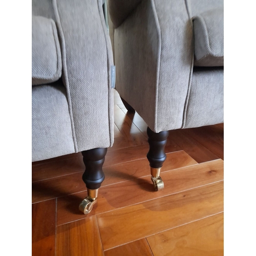 286 - A PAIR OF GREY UPHOLSTERED ARMCHAIRS, on turned leg with castors. Dimensions: 84cm wide x 82cm high ... 