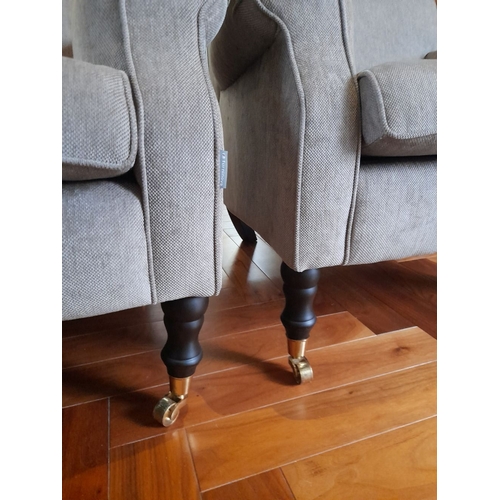 286 - A PAIR OF GREY UPHOLSTERED ARMCHAIRS, on turned leg with castors. Dimensions: 84cm wide x 82cm high ... 