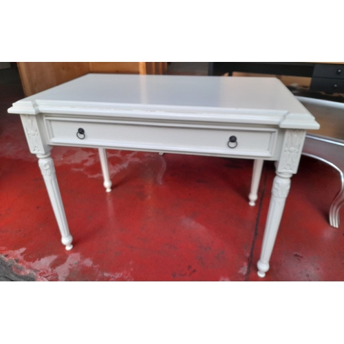 290 - A WHITE PAINTED ONE DRAWER DESK, with shaped top, one long drawer with drop handles, raised on flute... 