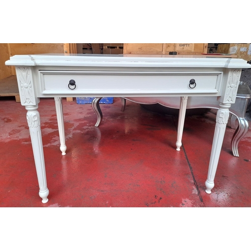 290 - A WHITE PAINTED ONE DRAWER DESK, with shaped top, one long drawer with drop handles, raised on flute... 