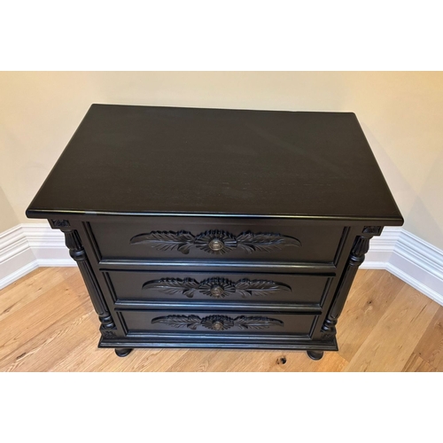 297 - A BLACK PAINTED THREE DRAWER CHEST OF DRAWERS, the three drawers with floral carved panels, between ... 