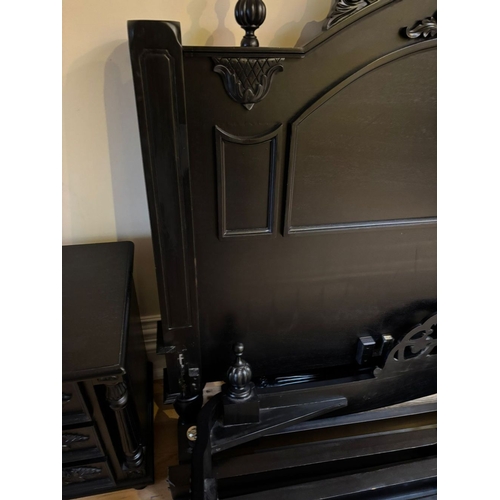 298 - A BLACK PAINTED CARVED HEADBOARD & FRAME, the headboard with carved mount to centre, between two fin... 