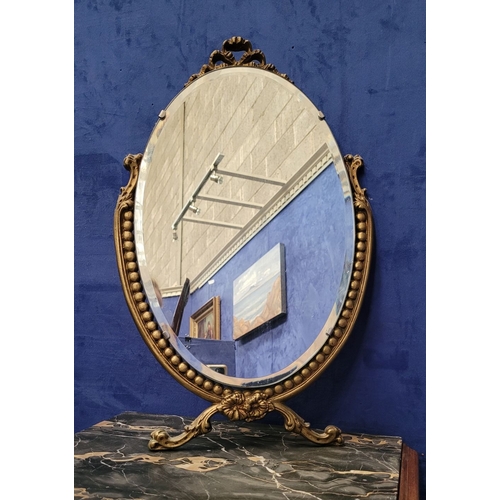 306 - A GILT FRAMED WALL MIRROR, with bevelled glass in an oval shape held within the frame, the frame wit... 