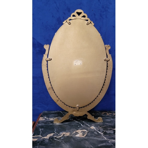 306 - A GILT FRAMED WALL MIRROR, with bevelled glass in an oval shape held within the frame, the frame wit... 