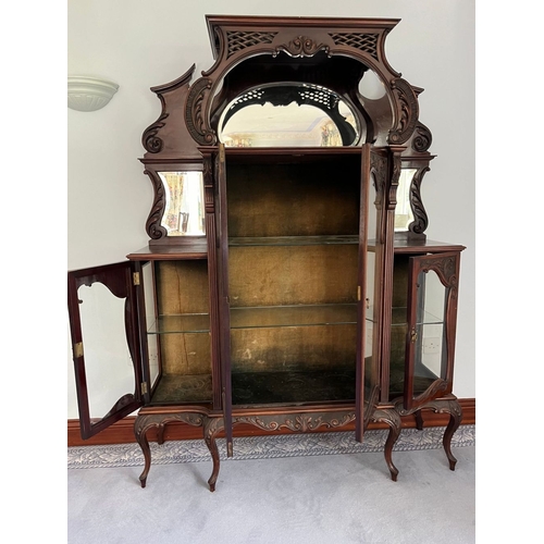 310 - A JACOBEAN STYLE GLAZED DISPLAY CABINET, with large oval mirror panelled back, above two smaller sha... 