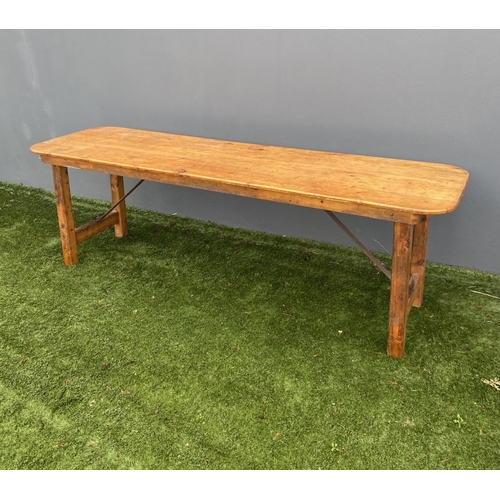 329 - A LARGE PINE TRESTLE TABLE, long rectangular top with canted corners, raised on four straight legs j... 