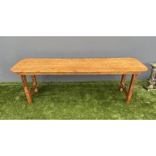 329 - A LARGE PINE TRESTLE TABLE, long rectangular top with canted corners, raised on four straight legs j... 