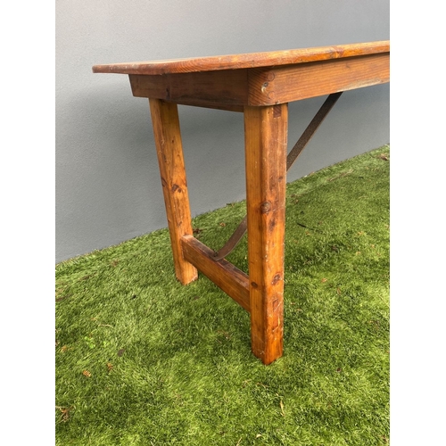 329 - A LARGE PINE TRESTLE TABLE, long rectangular top with canted corners, raised on four straight legs j... 