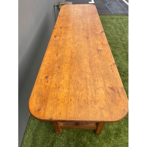 329 - A LARGE PINE TRESTLE TABLE, long rectangular top with canted corners, raised on four straight legs j... 