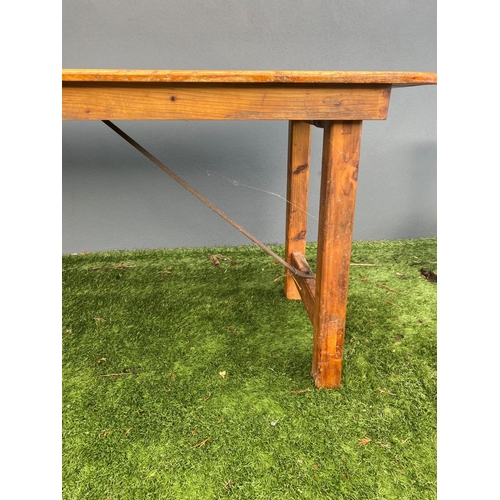 329 - A LARGE PINE TRESTLE TABLE, long rectangular top with canted corners, raised on four straight legs j... 