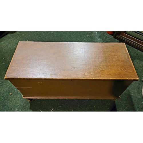 48 - AN OLD WOODEN BLANKET CHEST BOX, with hinged lid, raised on bracket feet. Top opens to reveal storag... 