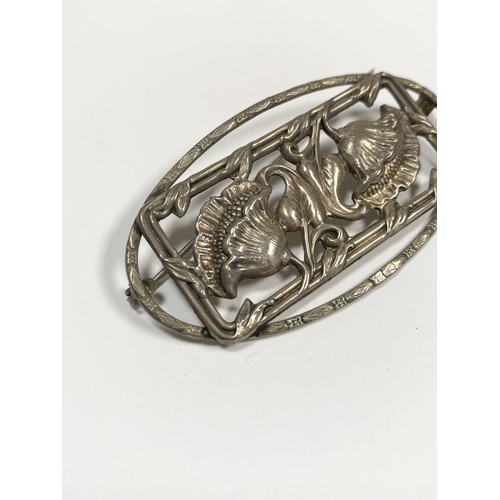 62 - A BEAUTIFUL ART NOUVEAU STERLING SILVER FLOWER BROOCH, featuring two flowers within openwork rectang... 