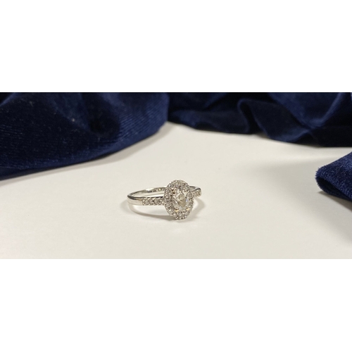 71 - A STUNNING 14CT WHITE GOLD DIAMOND CLUSTER RING, with central oval brilliant cut diamond, weight: .5... 