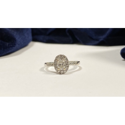 71 - A STUNNING 14CT WHITE GOLD DIAMOND CLUSTER RING, with central oval brilliant cut diamond, weight: .5... 