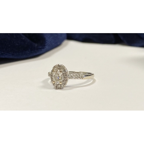 71 - A STUNNING 14CT WHITE GOLD DIAMOND CLUSTER RING, with central oval brilliant cut diamond, weight: .5... 