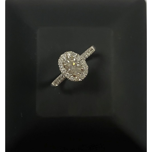 71 - A STUNNING 14CT WHITE GOLD DIAMOND CLUSTER RING, with central oval brilliant cut diamond, weight: .5... 