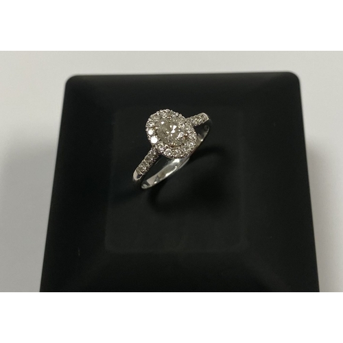 71 - A STUNNING 14CT WHITE GOLD DIAMOND CLUSTER RING, with central oval brilliant cut diamond, weight: .5... 