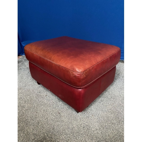 83 - A DEEP RED LEATHER OTTOMAN, on short shaped feet. Dimensions: 74cm x 54cm x 43cm high approx.