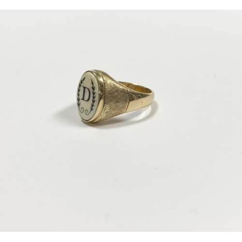 87 - A 14CT YELLOW GOLD ‘D’ ENGRAVED SIGNET RING, with central oval inset carved ‘D’ between fleur de lis... 