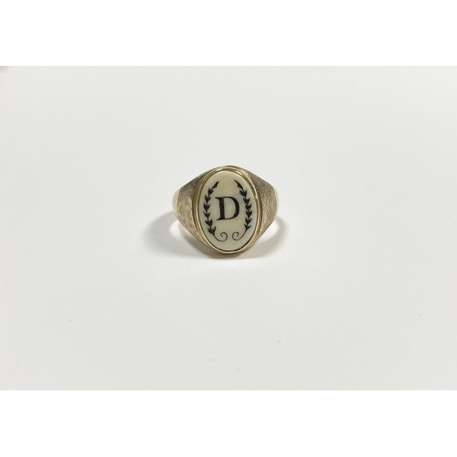 87 - A 14CT YELLOW GOLD ‘D’ ENGRAVED SIGNET RING, with central oval inset carved ‘D’ between fleur de lis... 