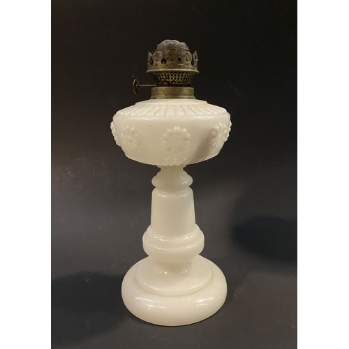 161 - AN ANTIQUE MILK GLASS OIL LAMP, the font with moulded flowers surrounding, on Column base on circula... 