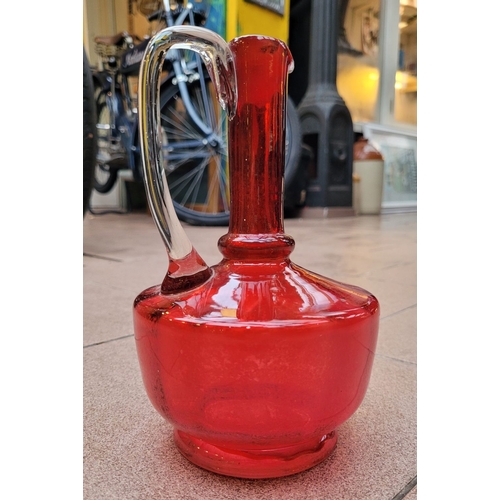 192 - A VERY GOOD ANTIQUE CRANBERRY GLASS DECANTER JUG, with clear glass curved handle, in very good/excel... 