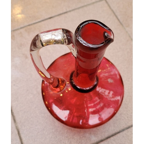 192 - A VERY GOOD ANTIQUE CRANBERRY GLASS DECANTER JUG, with clear glass curved handle, in very good/excel... 