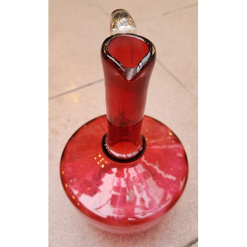 192 - A VERY GOOD ANTIQUE CRANBERRY GLASS DECANTER JUG, with clear glass curved handle, in very good/excel... 