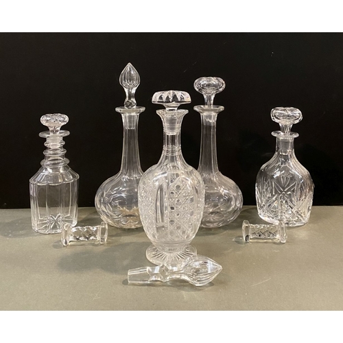 214 - A COLLECTION OF CUT GLASS DECANTERS & PAIR OF KNIFE RESTS, the decanters of various forms with a var... 