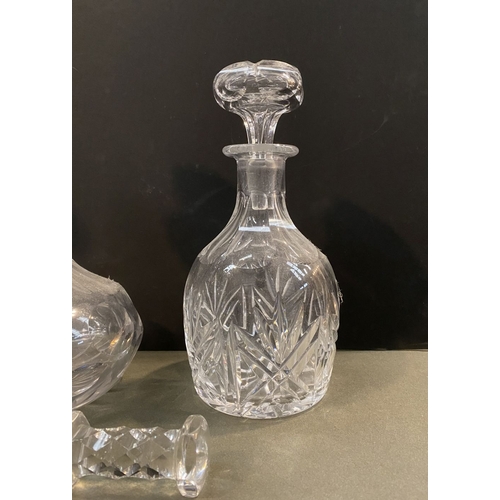 214 - A COLLECTION OF CUT GLASS DECANTERS & PAIR OF KNIFE RESTS, the decanters of various forms with a var... 