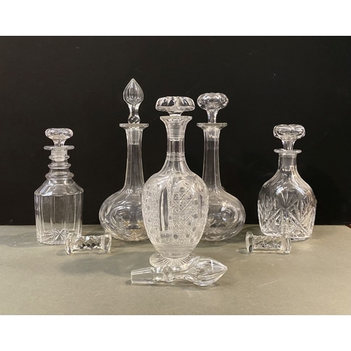 214 - A COLLECTION OF CUT GLASS DECANTERS & PAIR OF KNIFE RESTS, the decanters of various forms with a var... 