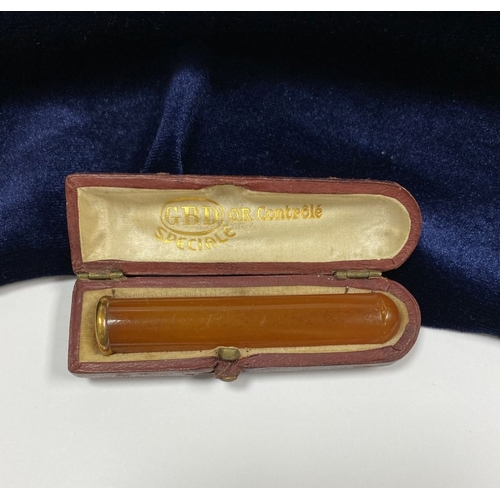 23 - A VINTAGE FRENCH CASED 9CT YELLOW GOLD CIGARETTE HOLDER, amber with gold mounted top, marks rubbed, ... 