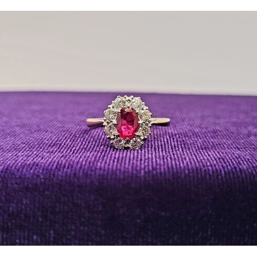 26 - A GORGEOUS 18CT YELLOW GOLD & PLATINUM DIAMOND & RUBY CLUSTER RING, an oval cut ruby is set to the c... 