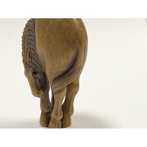 35 - AN ANTIQUE HAND CARVED JAPANESE BOXWOOD NETSUKE, in the form of a horse, signed to reverse on inlaid... 